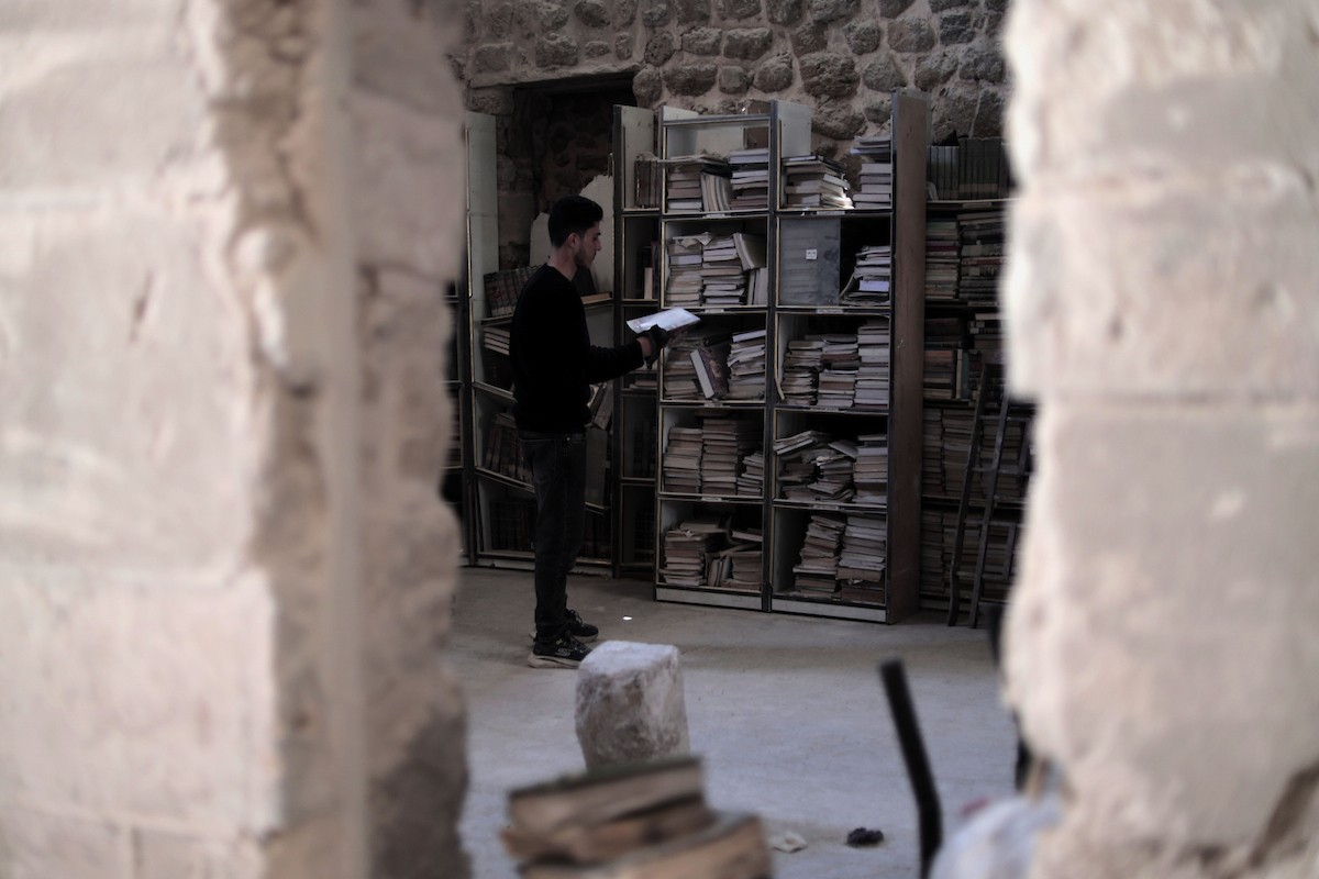 يتردد الشاب الفلسطيني كريم الخضري على مكتبة الجامع الكبير بغزة (الجامع العمري) في البلدة القديمة، شرق مدينة غزة، حيث يقوم بتنظيف الكتب وترتيبها بجدٍّ واجتهاد، 26 أبريل/نيسان 2026. تصوير: محمد الأسود