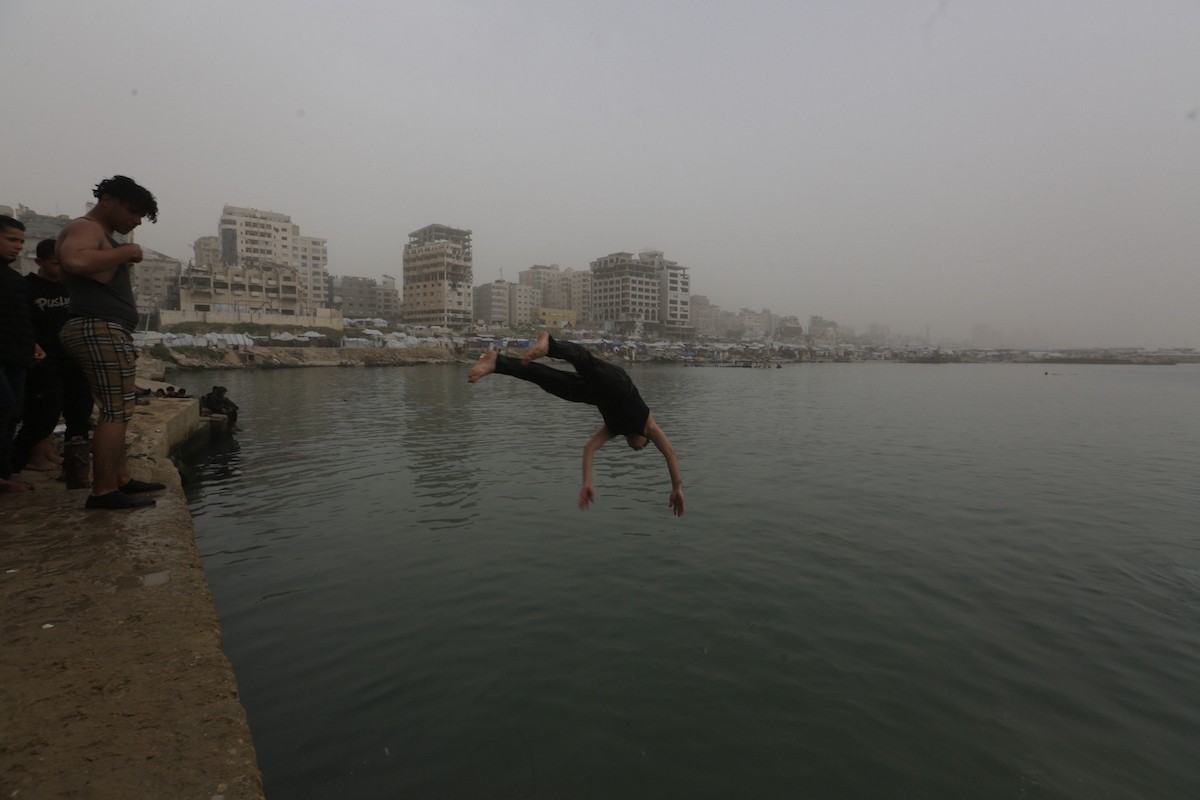 يقضي أطفال فلسطينيون أوقاتهم على شاطئ  غزة، باحثين عن ملاذ من حرارة الشمس وضغوط الحياة اليومية، في ظلّ الظروف الإنسانية المتردية التي يواجهها سكان القطاع جراء الحرب الدائرة، 17 أبريل/نيسان 2026. تصوير: بلال أسامة