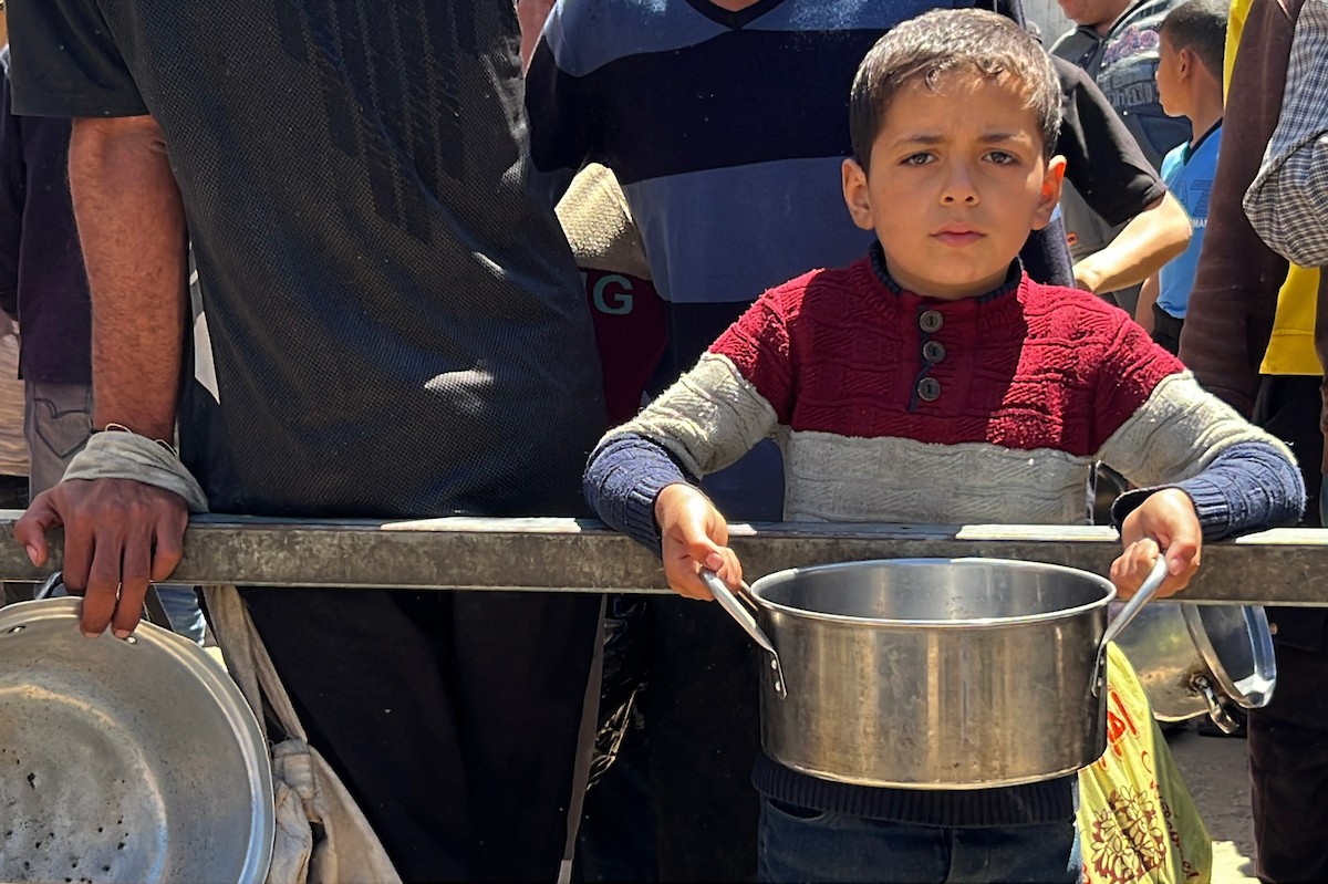 يتلقى فلسطينيون نازحون طعامًا من مطبخ خيري في مخيم النصيرات للاجئين وسط قطاع غزة، في 23 أبريل/نيسان 2026، (صورة: يوسف أبو وطفة)