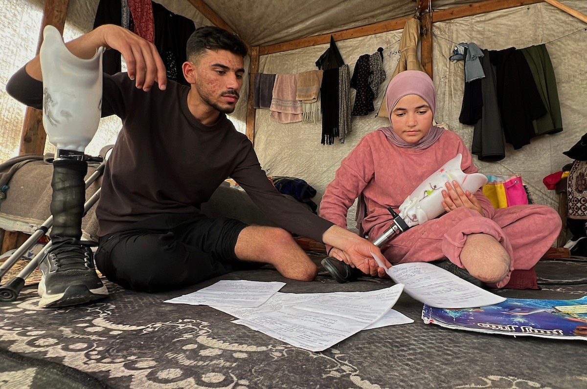 منة وائل عاشور (12 عاماً) وشقيقها فايز (24 عاماً) يعيشان في خيمة نزوح بمدينة دير البلح وسط قطاع غزة، بعد أن فقدا أطرافهما جراء هجوم إسرائيلي قبل نحو تسعة أشهر، 16 أبريل/نيسان 2026. صورة: يوسف أبو طفة