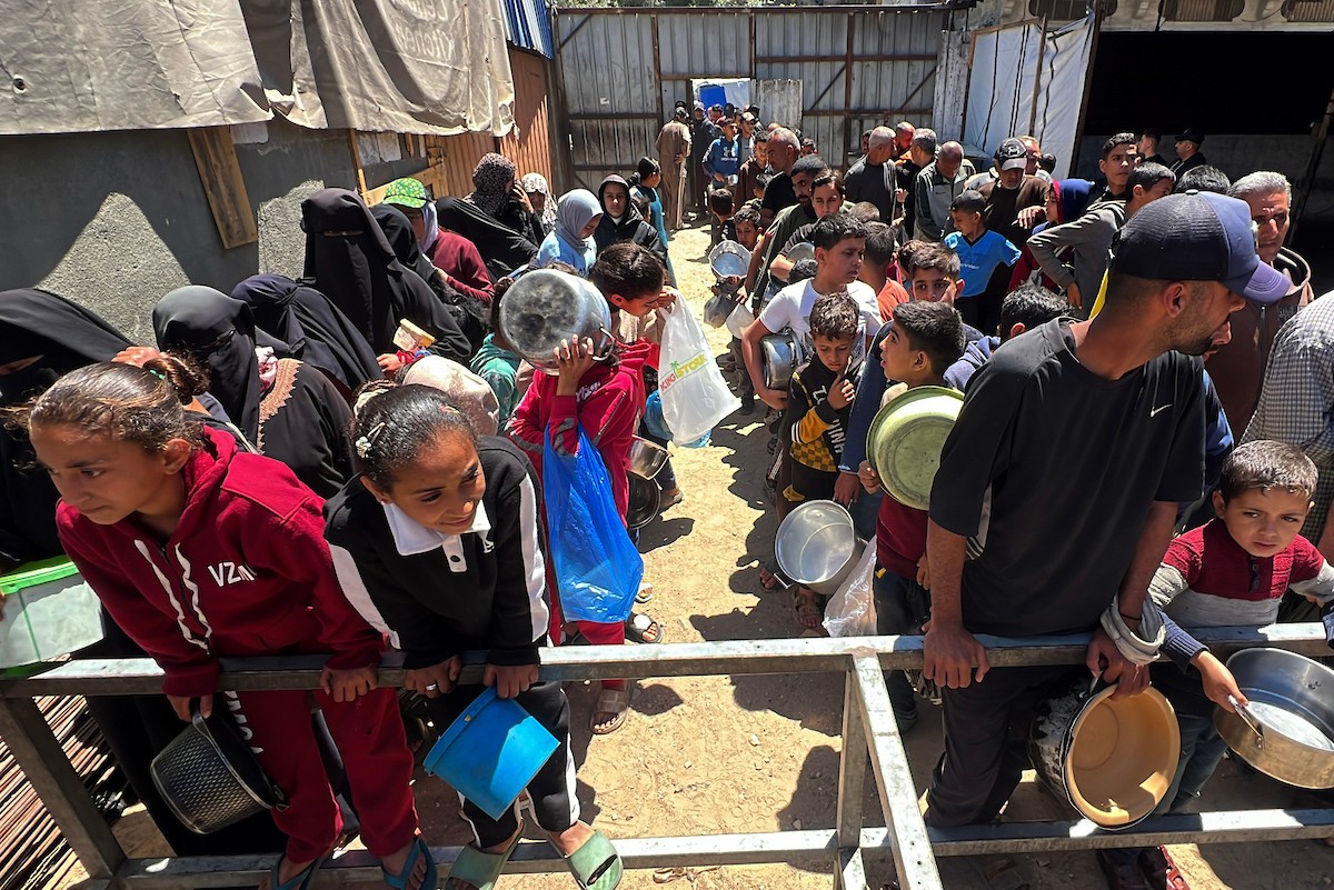 يتلقى فلسطينيون نازحون طعامًا من مطبخ خيري في مخيم النصيرات للاجئين وسط قطاع غزة، في 23 أبريل/نيسان 2026، (صورة: يوسف أبو وطفة)