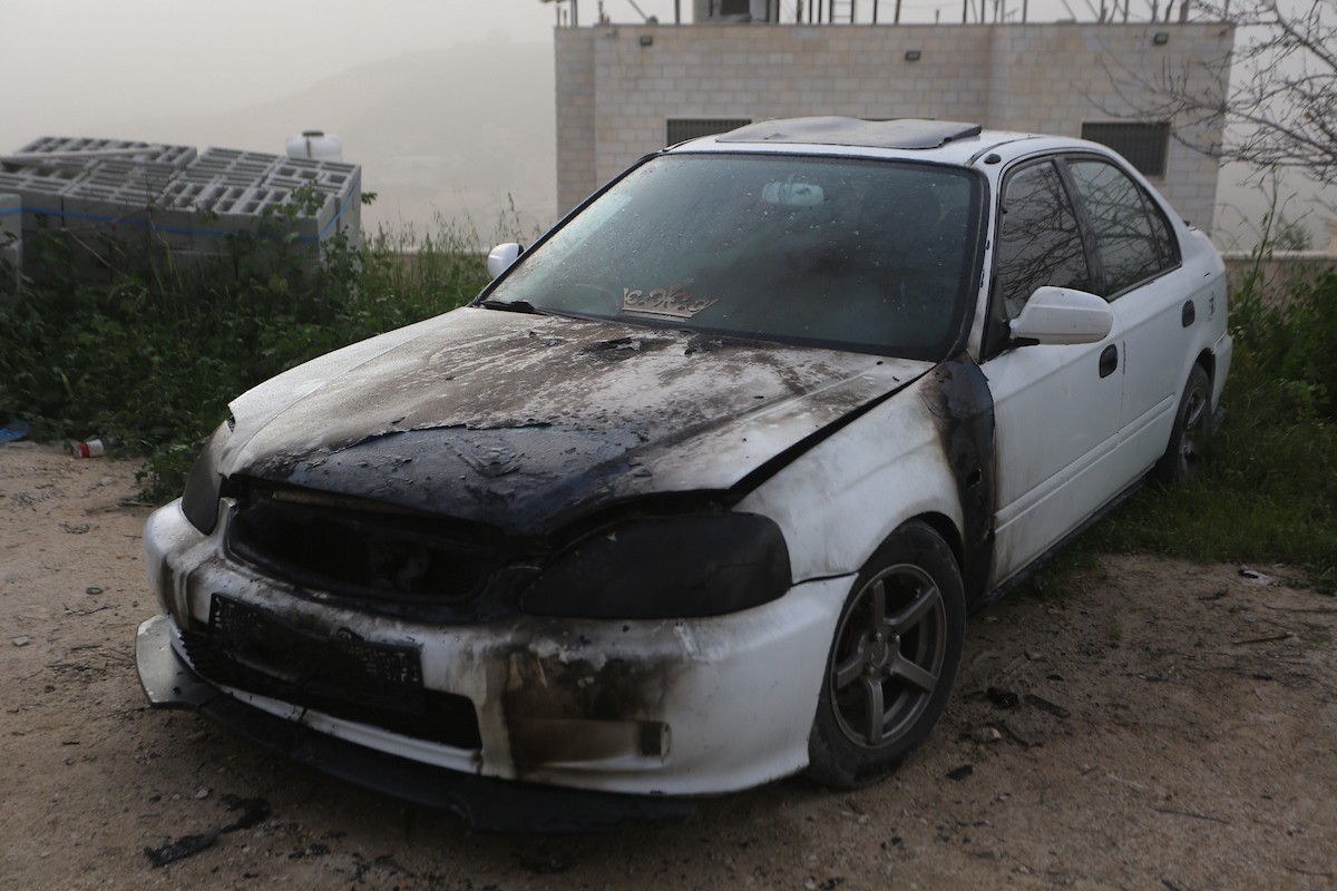 يقف فلسطينيون وسط آثار الدمار في قرية عورتا جنوب نابلس شمال الضفة الغربية، عقب هجوم نفذه مستوطنون إسرائيليون استهدف مركبات ومنازل المواطنين، مخلّفًا أضرارًا واسعة، وفق شهود عيان. 17 أبريل/نيسان 2026. تصوير: محمد ناصر.