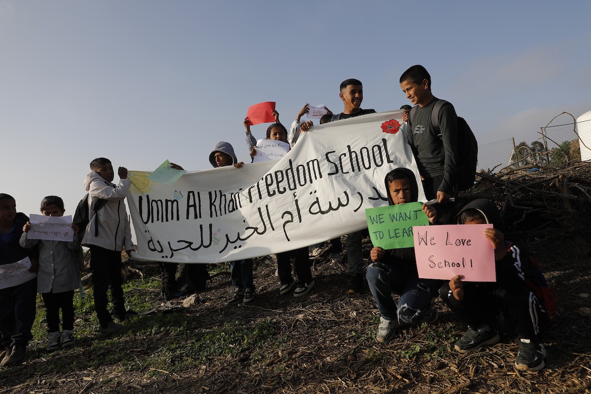 الخليل - أطفال خربة أم الخير وبمشاركة نشطاء سلام دوليين ينظمون وقفة سلمية احتجاجا على إغلاق الجيش الإسرائيلي للطريق الرئيسي المؤدي إلى مدارسهم منذ أسبوع، 19 أبريل/نيسان 2026. تصوير: مأمون وزواز