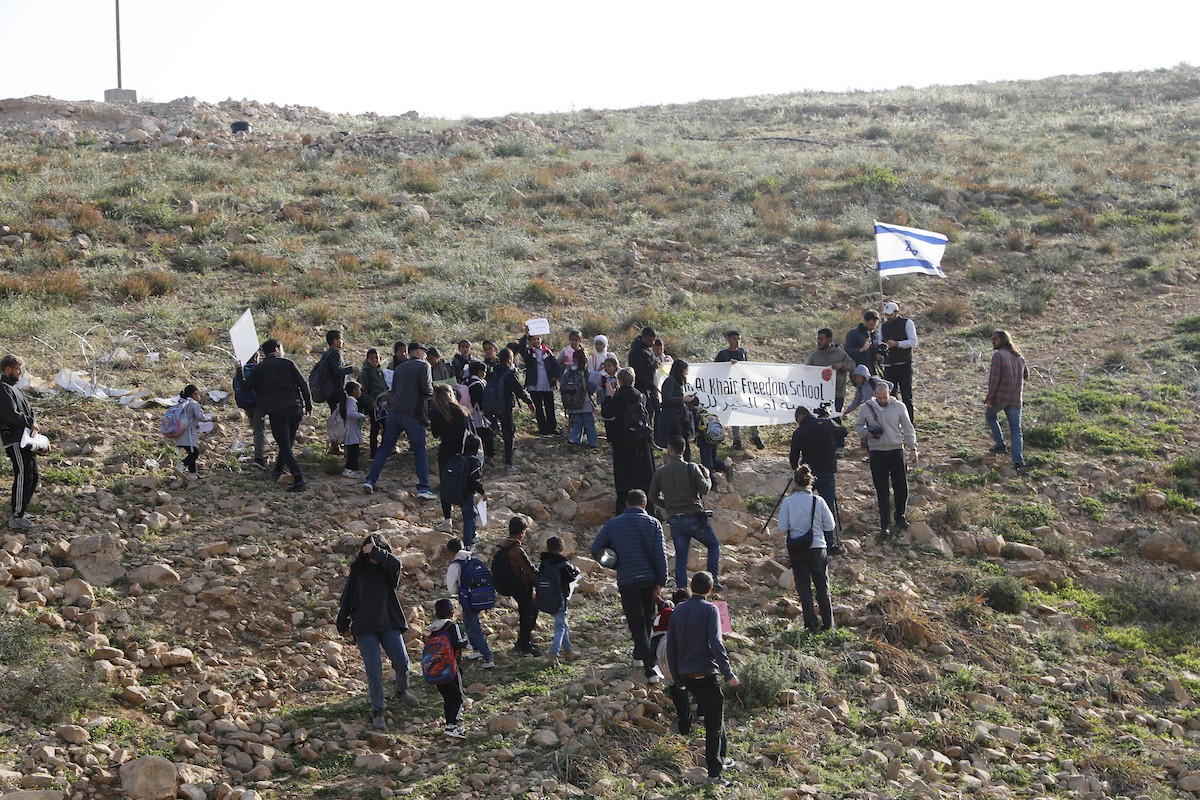 الخليل - أطفال خربة أم الخير وبمشاركة نشطاء سلام دوليين ينظمون وقفة سلمية احتجاجا على إغلاق الجيش الإسرائيلي للطريق الرئيسي المؤدي إلى مدارسهم منذ أسبوع، 19 أبريل/نيسان 2026. تصوير: مأمون وزواز