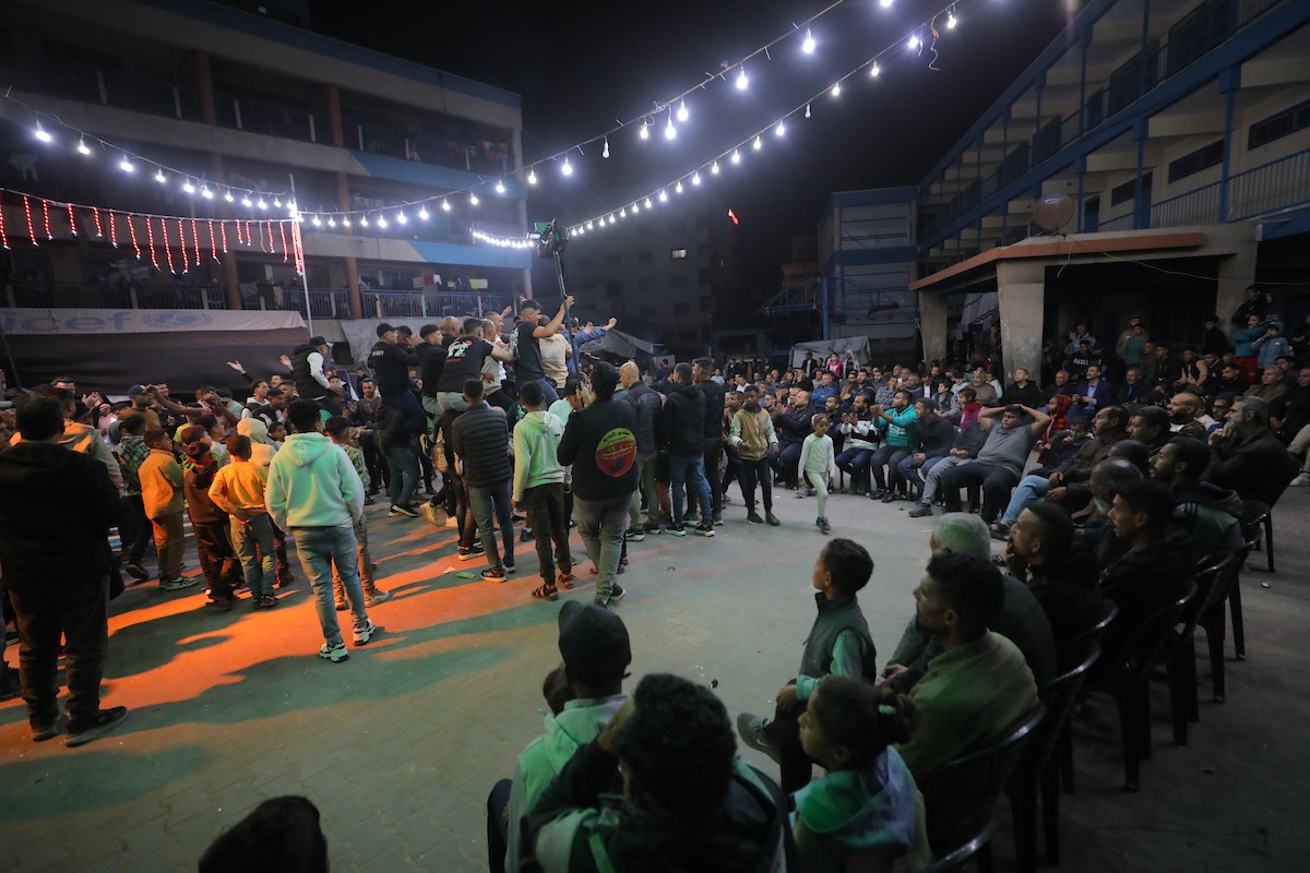 فلسطينيون نازحون يشاركون في حفل زفاف الشاب ماهر حمدية داخل مدرسة حُوّلت إلى مأوى في مخيم النصيرات، وسط قطاع غزة، 26 أبريل/نيسان 2026. (تصوير: حسن الجديدي)