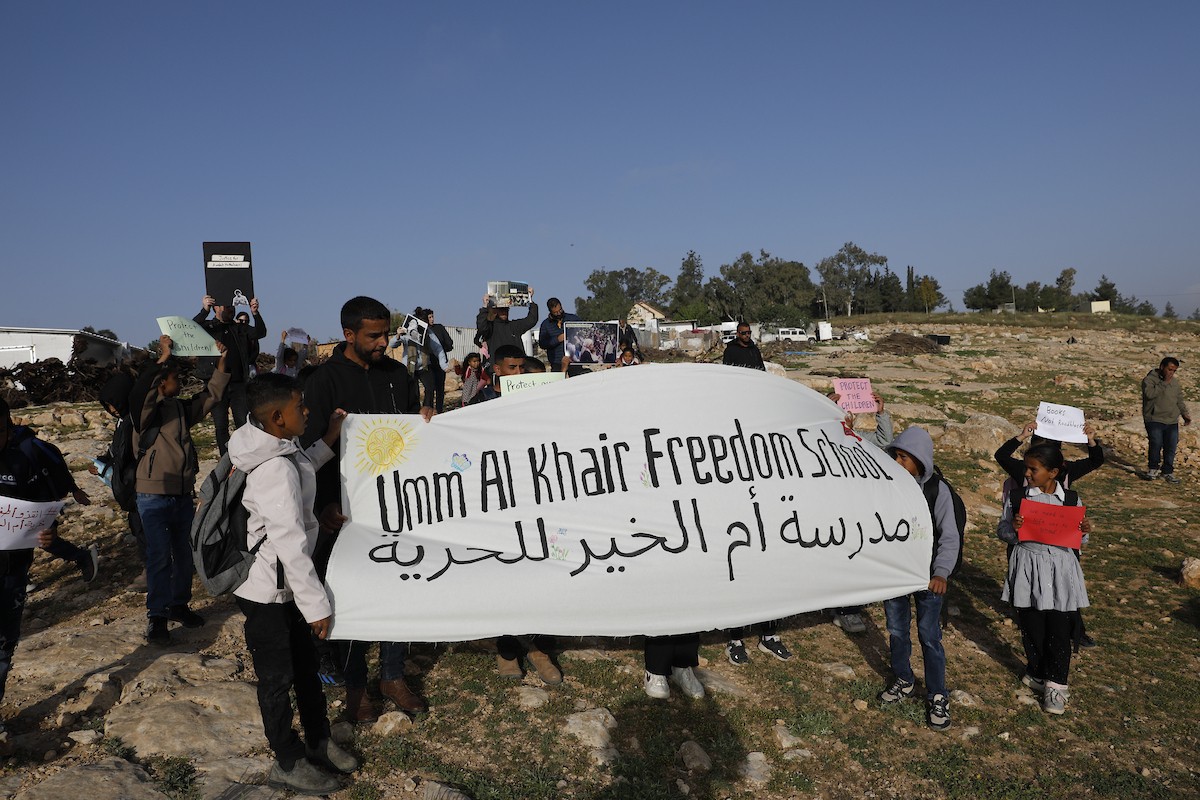 الخليل - أطفال خربة أم الخير وبمشاركة نشطاء سلام دوليين ينظمون وقفة سلمية احتجاجا على إغلاق الجيش الإسرائيلي للطريق الرئيسي المؤدي إلى مدارسهم منذ أسبوع، 19 أبريل/نيسان 2026. تصوير: مأمون وزواز