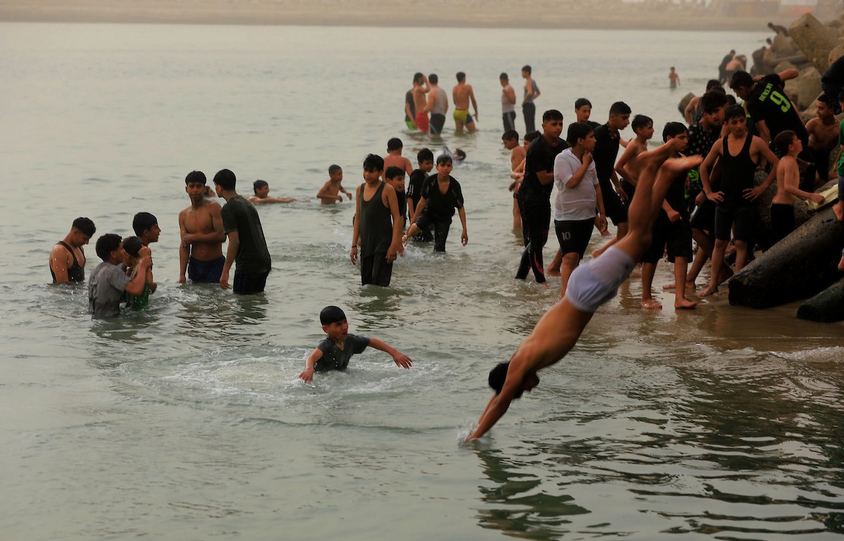 يقضي أطفال فلسطينيون أوقاتهم على شاطئ  غزة، باحثين عن ملاذ من حرارة الشمس وضغوط الحياة اليومية، في ظلّ الظروف الإنسانية المتردية التي يواجهها سكان القطاع جراء الحرب الدائرة، 17 أبريل/نيسان 2026. تصوير: بلال أسامة