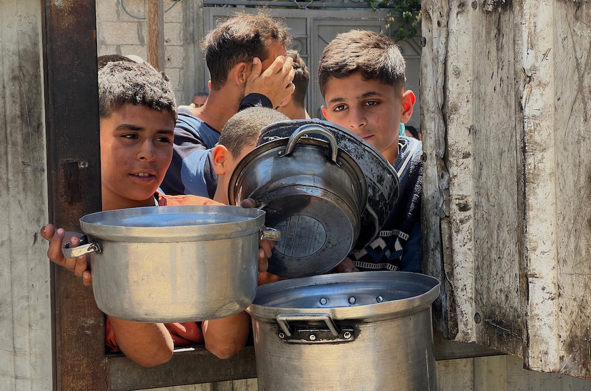 يتلقى فلسطينيون نازحون طعامًا من مطبخ خيري في مخيم النصيرات للاجئين وسط قطاع غزة، في 23 أبريل/نيسان 2026، (صورة: يوسف أبو وطفة)