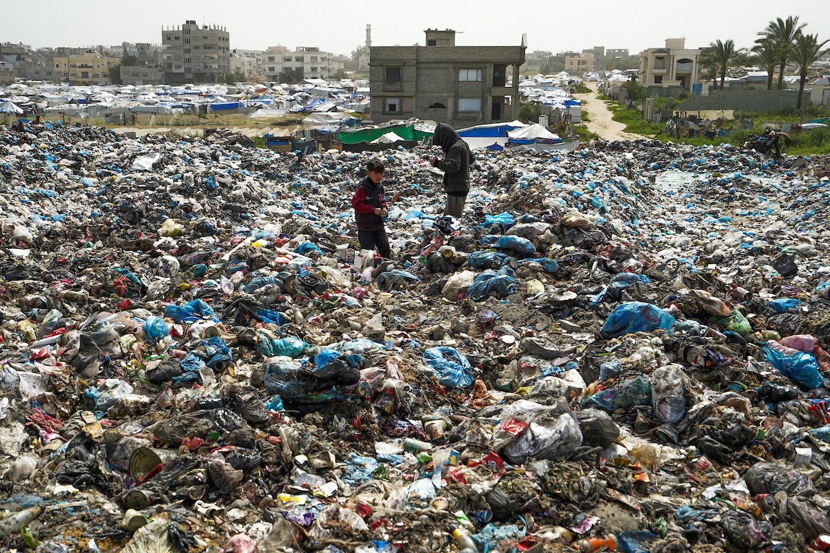 أطفال فلسطينيون يبحثون بين أكوام القمامة عن بقايا الطعام أو الألعاب في مكب نفايات بمخيم البريج للاجئين وسط قطاع غزة، في 4 أبريل/نيسان 2026، بالتزامن مع يوم الطفل الفلسطيني.(صورة: رمزي أبو عامر)