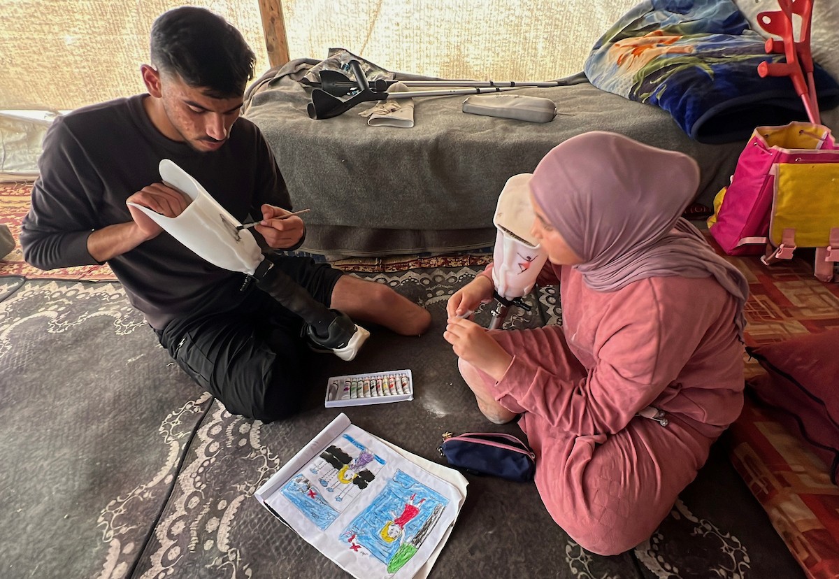 منة وائل عاشور (12 عاماً) وشقيقها فايز (24 عاماً) يعيشان في خيمة نزوح بمدينة دير البلح وسط قطاع غزة، بعد أن فقدا أطرافهما جراء هجوم إسرائيلي قبل نحو تسعة أشهر، 16 أبريل/نيسان 2026. صورة: يوسف أبو طفة