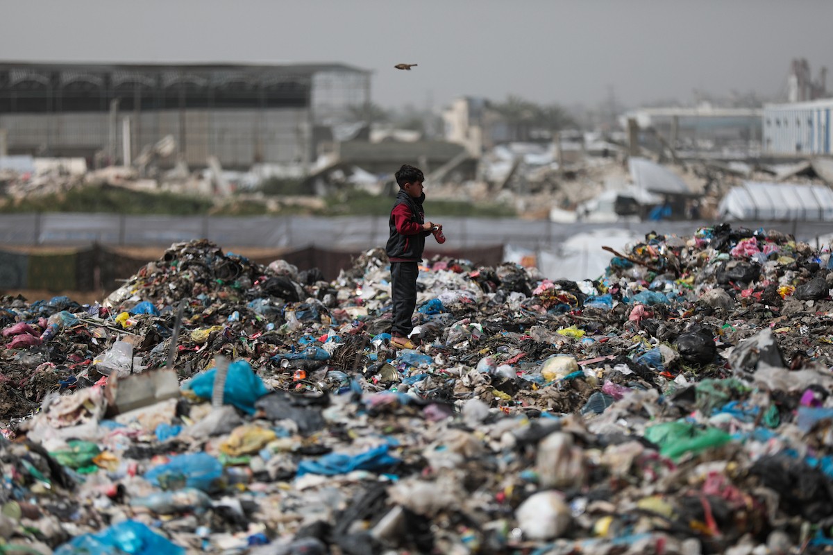 أطفال فلسطينيون يبحثون بين أكوام القمامة عن بقايا الطعام أو الألعاب في مكب نفايات بمخيم البريج للاجئين وسط قطاع غزة، في 4 أبريل/نيسان 2026، بالتزامن مع يوم الطفل الفلسطيني.(صورة: رمزي أبو عامر)
