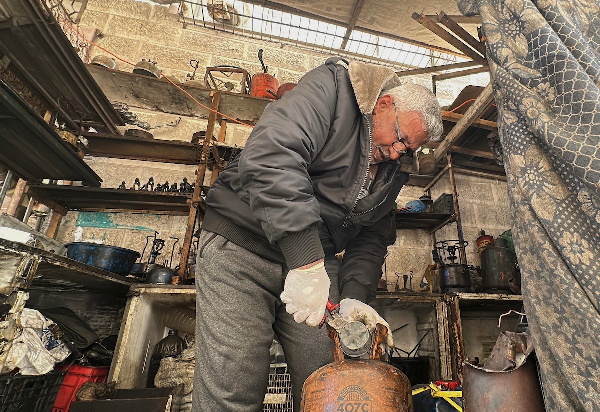عادل عيسى، 63 عامًا، يُصلح مواقد الكيروسين القديمة في ورشته بمخيم الشاطئ، في مدينة غزة، صورة فوتوغرافية لهادي داود