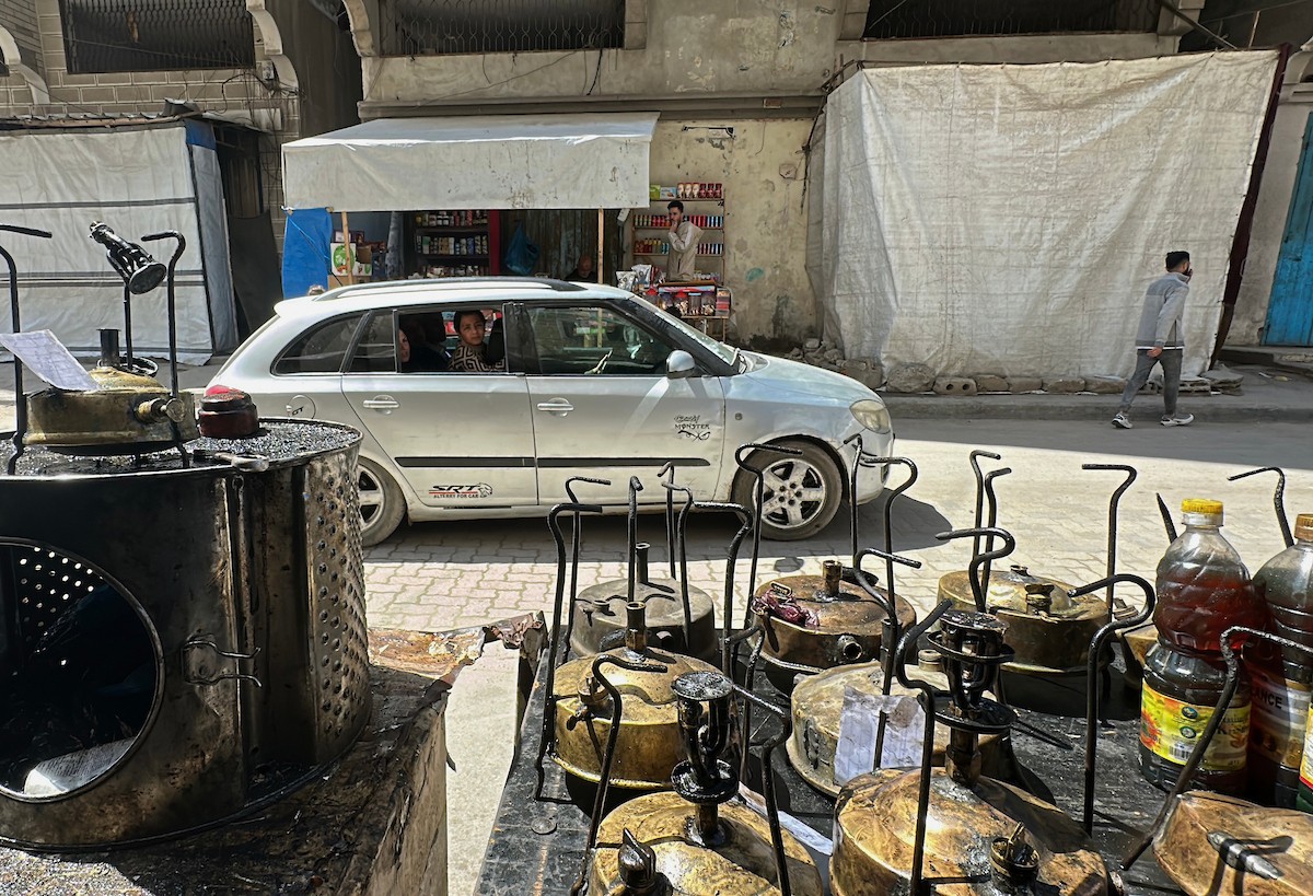 عادل عيسى، 63 عامًا، يُصلح مواقد الكيروسين القديمة في ورشته بمخيم الشاطئ، في مدينة غزة، صورة فوتوغرافية لهادي داود