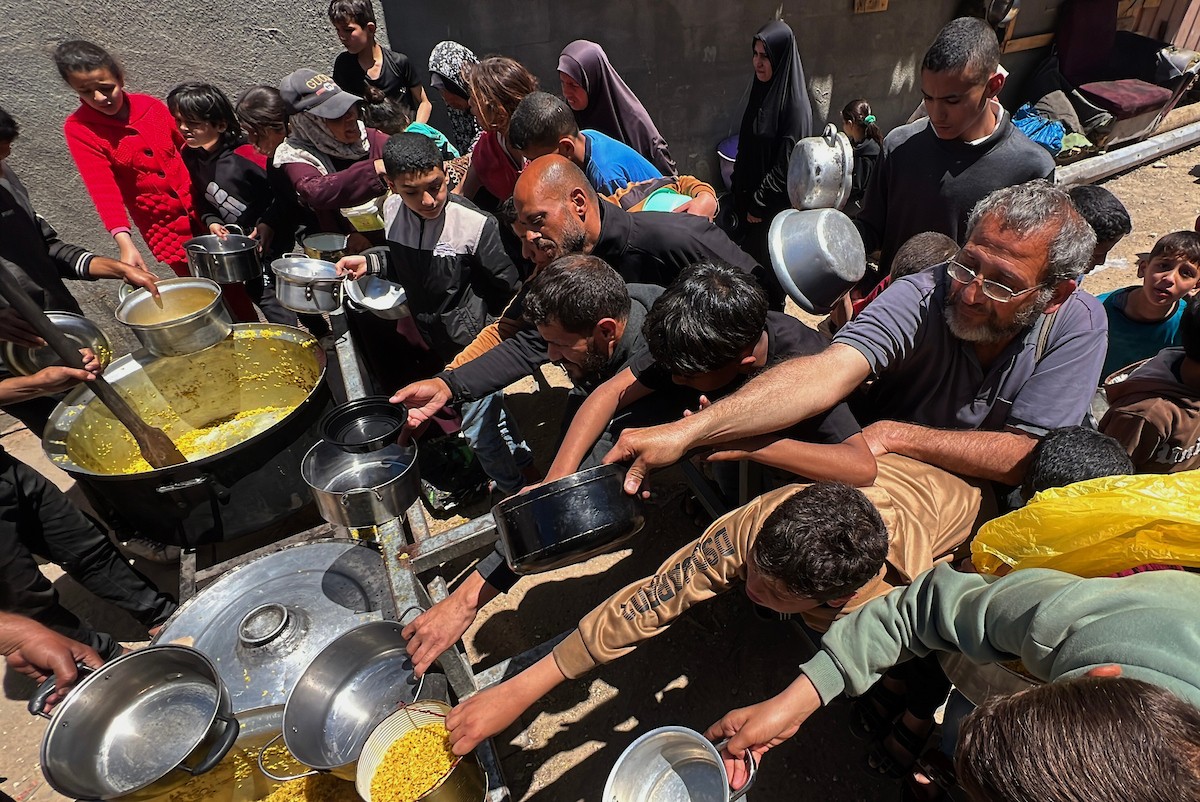 يتلقى فلسطينيون نازحون طعامًا من مطبخ خيري في مخيم النصيرات للاجئين وسط قطاع غزة، في 23 أبريل/نيسان 2026، (صورة: يوسف أبو وطفة)
