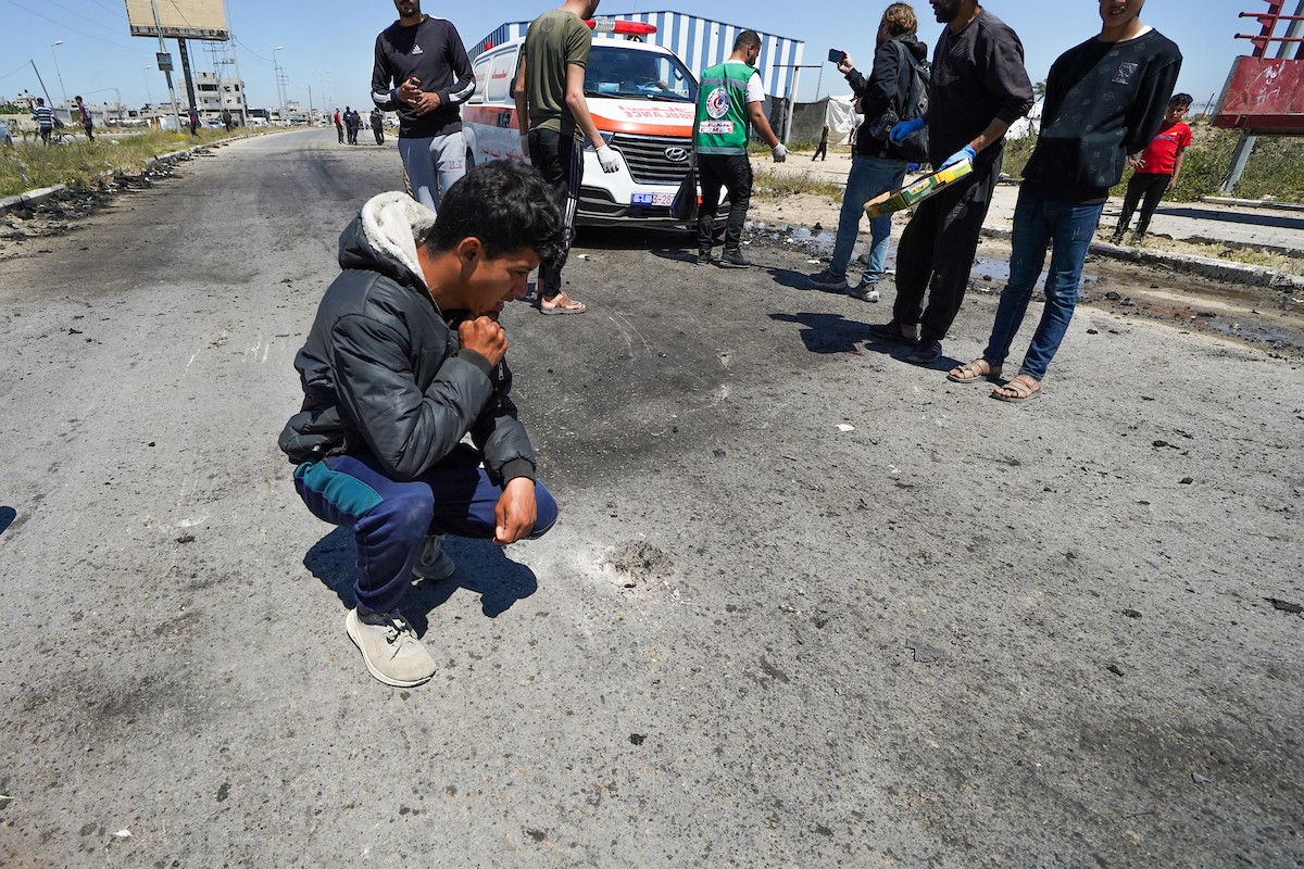 فلسطينيون يتفقدون سيارة مدنية مدمرة بعد استهدافها في غارة جوية إسرائيلية أسفرت عن مقتل ثلاثة أشخاص في شارع صلاح الدين، جنوب مخيم البريج للاجئين وسط قطاع غزة، 23 أبريل/نيسان 2026. صورة: رمزي أبو عامر