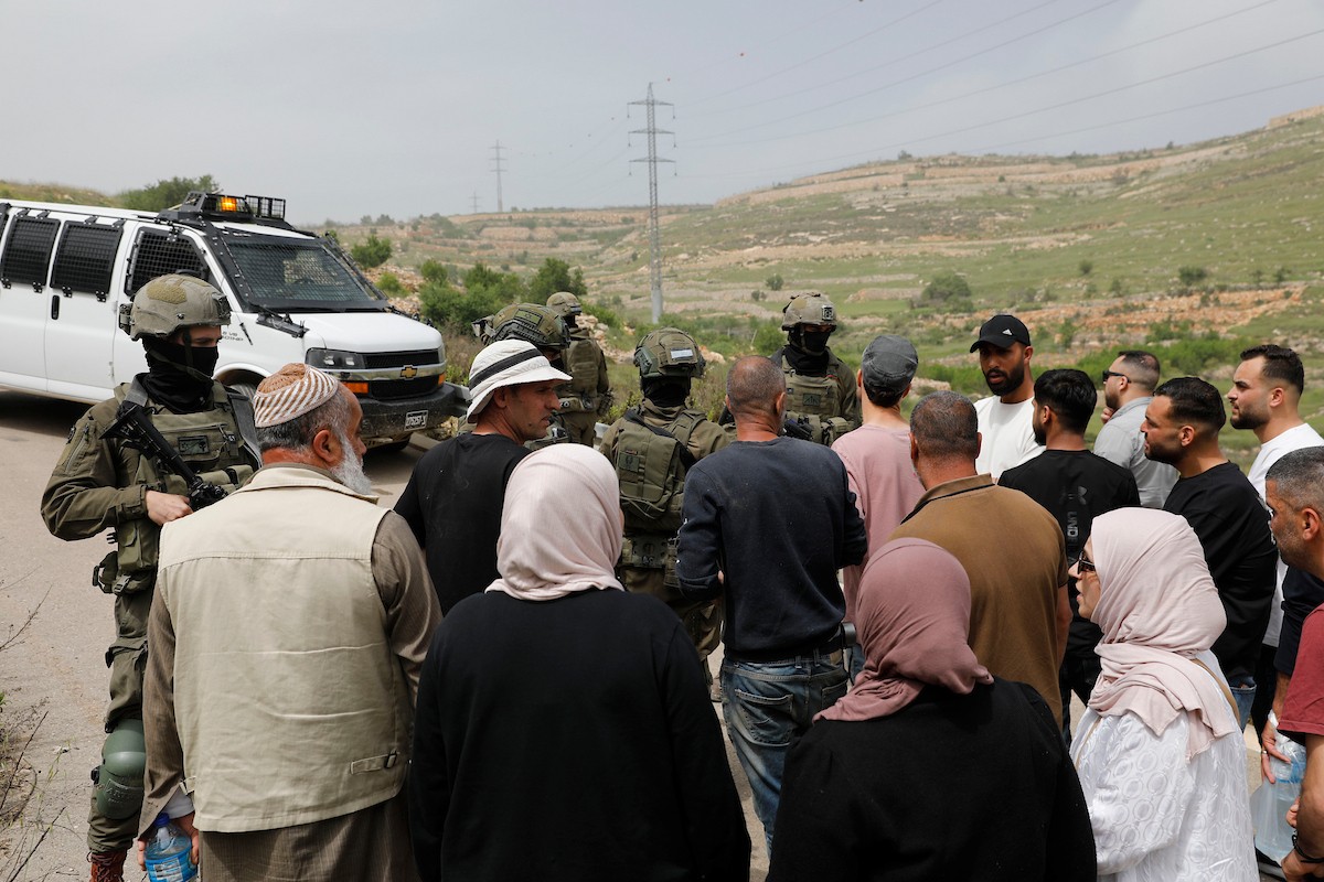 يحاول فلسطينيون الوصول إلى أراضيهم الزراعية في بلدة حلحول شمال الخليل جنوب الضفة الغربية، إلا أن الجيش الإسرائيلي يمنعهم من ذلك، وفق ما أفاد به شهود عيان،  17 أبريل/نيسان 2026. صورة: مأمون وزواز