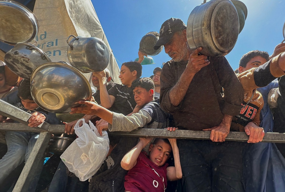 يتلقى فلسطينيون نازحون طعامًا من مطبخ خيري في مخيم النصيرات للاجئين وسط قطاع غزة، في 23 أبريل/نيسان 2026، (صورة: يوسف أبو وطفة)