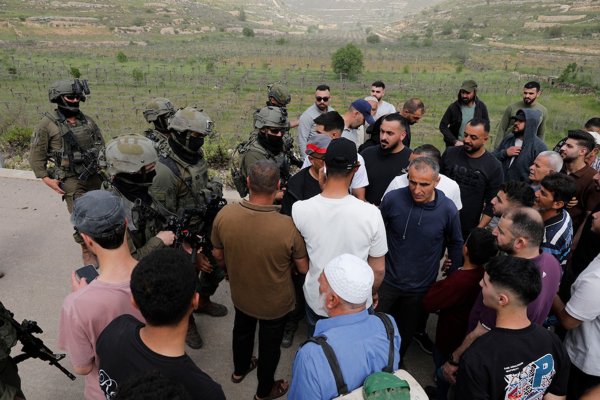 يحاول فلسطينيون الوصول إلى أراضيهم الزراعية في بلدة حلحول شمال الخليل جنوب الضفة الغربية، إلا أن الجيش الإسرائيلي يمنعهم من ذلك، وفق ما أفاد به شهود عيان،  17 أبريل/نيسان 2026. صورة: مأمون وزواز