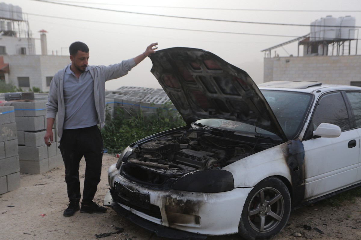 يقف فلسطينيون وسط آثار الدمار في قرية عورتا جنوب نابلس شمال الضفة الغربية، عقب هجوم نفذه مستوطنون إسرائيليون استهدف مركبات ومنازل المواطنين، مخلّفًا أضرارًا واسعة، وفق شهود عيان. 17 أبريل/نيسان 2026. تصوير: محمد ناصر.