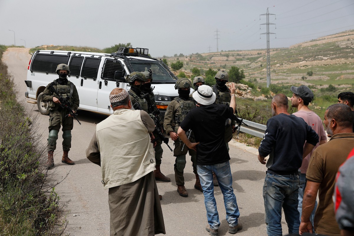 يحاول فلسطينيون الوصول إلى أراضيهم الزراعية في بلدة حلحول شمال الخليل جنوب الضفة الغربية، إلا أن الجيش الإسرائيلي يمنعهم من ذلك، وفق ما أفاد به شهود عيان،  17 أبريل/نيسان 2026. صورة: مأمون وزواز