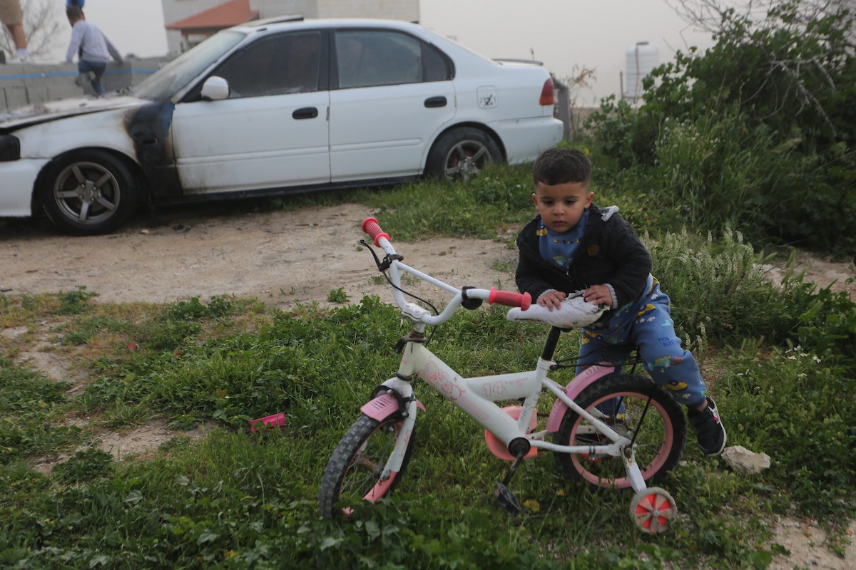 يقف فلسطينيون وسط آثار الدمار في قرية عورتا جنوب نابلس شمال الضفة الغربية، عقب هجوم نفذه مستوطنون إسرائيليون استهدف مركبات ومنازل المواطنين، مخلّفًا أضرارًا واسعة، وفق شهود عيان. 17 أبريل/نيسان 2026. تصوير: محمد ناصر.