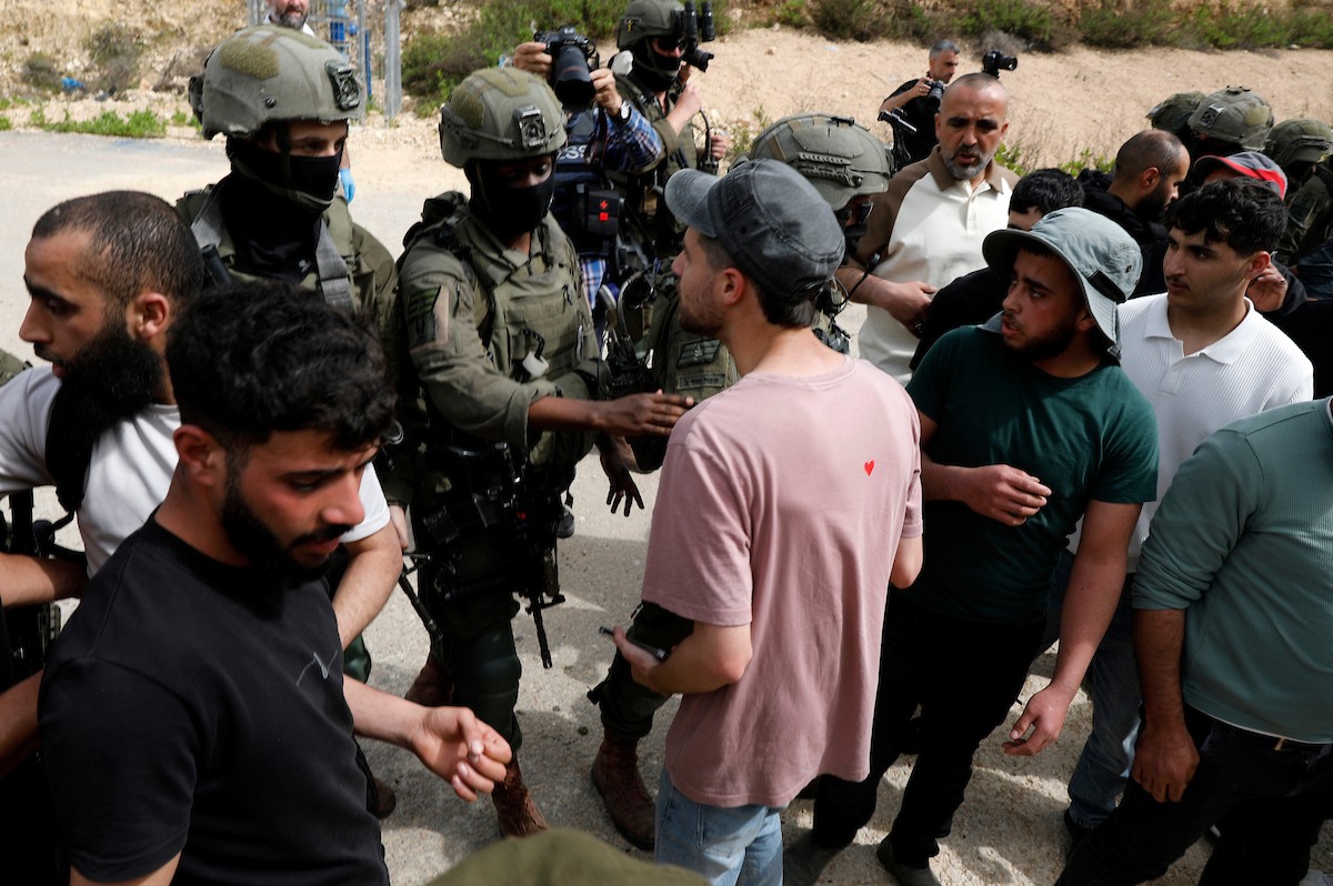 يحاول فلسطينيون الوصول إلى أراضيهم الزراعية في بلدة حلحول شمال الخليل جنوب الضفة الغربية، إلا أن الجيش الإسرائيلي يمنعهم من ذلك، وفق ما أفاد به شهود عيان،  17 أبريل/نيسان 2026. صورة: مأمون وزواز