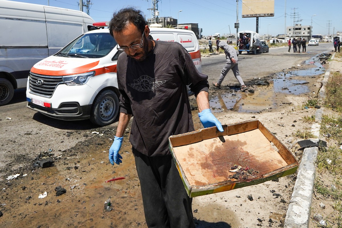 فلسطينيون يتفقدون سيارة مدنية مدمرة بعد استهدافها في غارة جوية إسرائيلية أسفرت عن مقتل ثلاثة أشخاص في شارع صلاح الدين، جنوب مخيم البريج للاجئين وسط قطاع غزة، 23 أبريل/نيسان 2026. صورة: رمزي أبو عامر