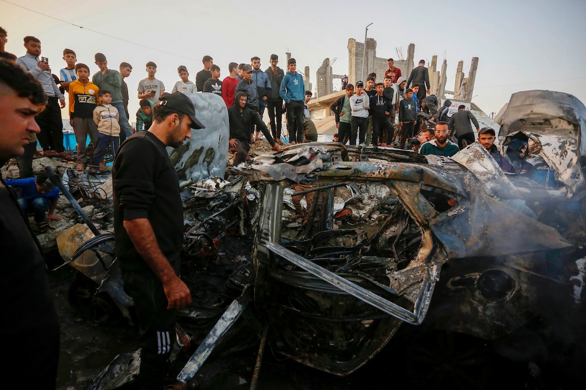 يتفقد فلسطينيون آثار غارة جوية إسرائيلية استهدفت مركبة في شارع صلاح الدين قرب مدخل مخيم المغازي للاجئين وسط قطاع غزة، في 4 أبريل/نيسان 2026.  (صورة: أحمد إبراهيم)