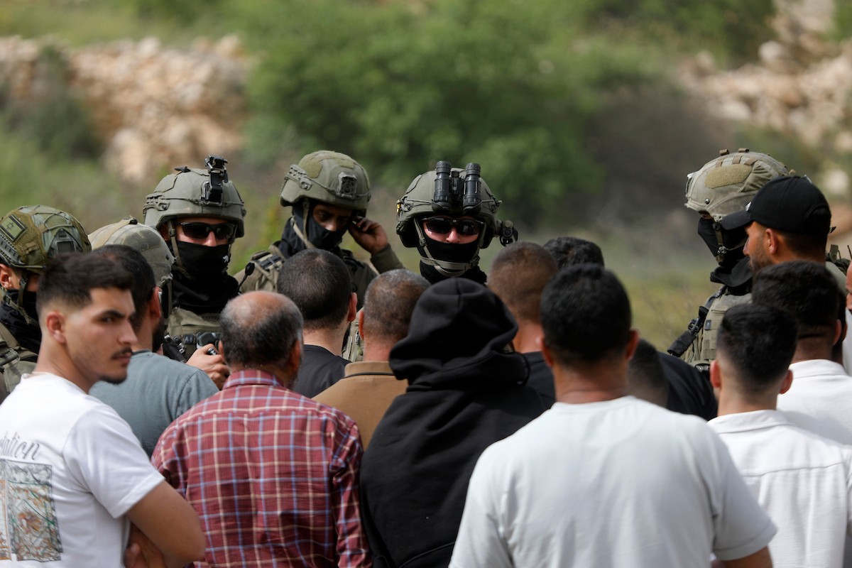 يحاول فلسطينيون الوصول إلى أراضيهم الزراعية في بلدة حلحول شمال الخليل جنوب الضفة الغربية، إلا أن الجيش الإسرائيلي يمنعهم من ذلك، وفق ما أفاد به شهود عيان،  17 أبريل/نيسان 2026. صورة: مأمون وزواز