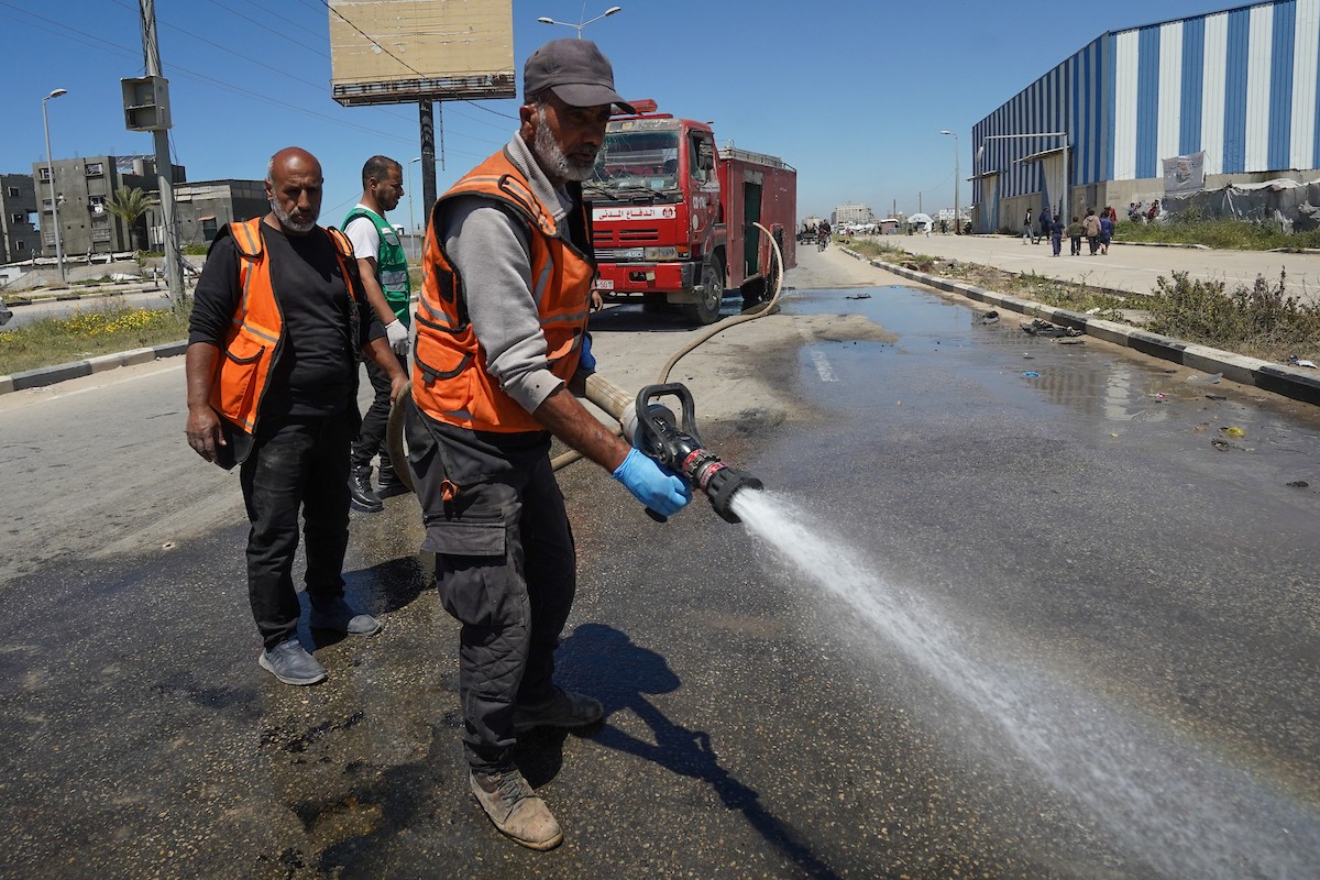 فلسطينيون يتفقدون سيارة مدنية مدمرة بعد استهدافها في غارة جوية إسرائيلية أسفرت عن مقتل ثلاثة أشخاص في شارع صلاح الدين، جنوب مخيم البريج للاجئين وسط قطاع غزة، 23 أبريل/نيسان 2026. صورة: رمزي أبو عامر
