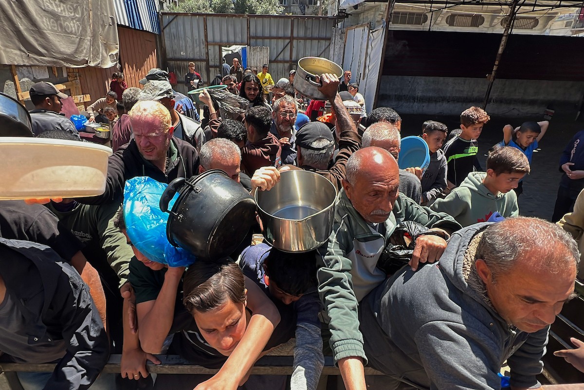 يتلقى فلسطينيون نازحون طعامًا من مطبخ خيري في مخيم النصيرات للاجئين وسط قطاع غزة، في 23 أبريل/نيسان 2026، (صورة: يوسف أبو وطفة)