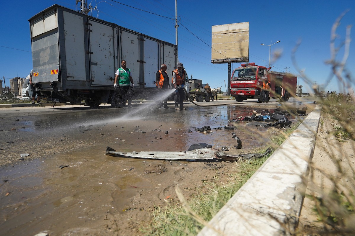 فلسطينيون يتفقدون سيارة مدنية مدمرة بعد استهدافها في غارة جوية إسرائيلية أسفرت عن مقتل ثلاثة أشخاص في شارع صلاح الدين، جنوب مخيم البريج للاجئين وسط قطاع غزة، 23 أبريل/نيسان 2026. صورة: رمزي أبو عامر