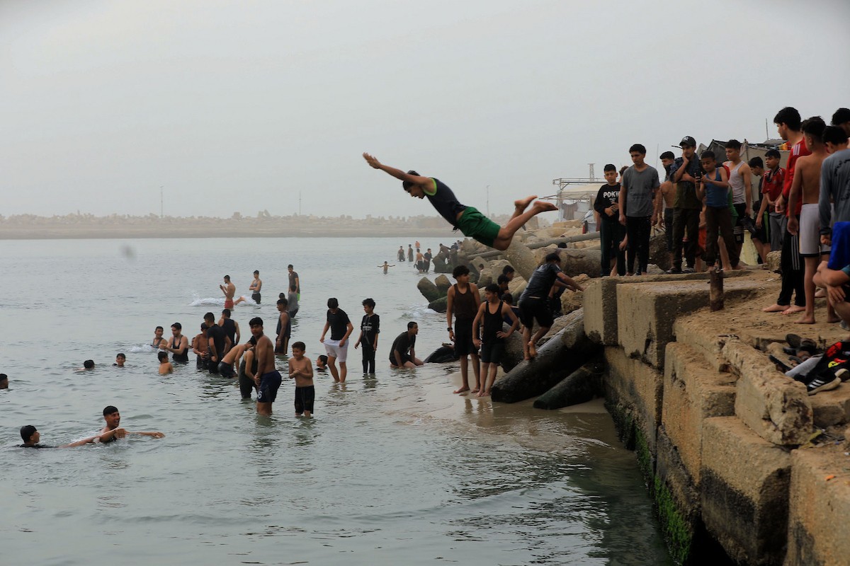 يقضي أطفال فلسطينيون أوقاتهم على شاطئ  غزة، باحثين عن ملاذ من حرارة الشمس وضغوط الحياة اليومية، في ظلّ الظروف الإنسانية المتردية التي يواجهها سكان القطاع جراء الحرب الدائرة، 17 أبريل/نيسان 2026. تصوير: بلال أسامة