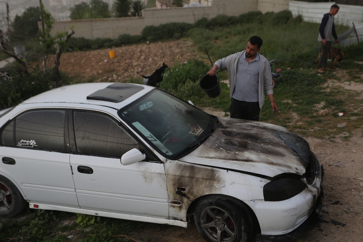 يقف فلسطينيون وسط آثار الدمار في قرية عورتا جنوب نابلس شمال الضفة الغربية، عقب هجوم نفذه مستوطنون إسرائيليون استهدف مركبات ومنازل المواطنين، مخلّفًا أضرارًا واسعة، وفق شهود عيان. 17 أبريل/نيسان 2026. تصوير: محمد ناصر.