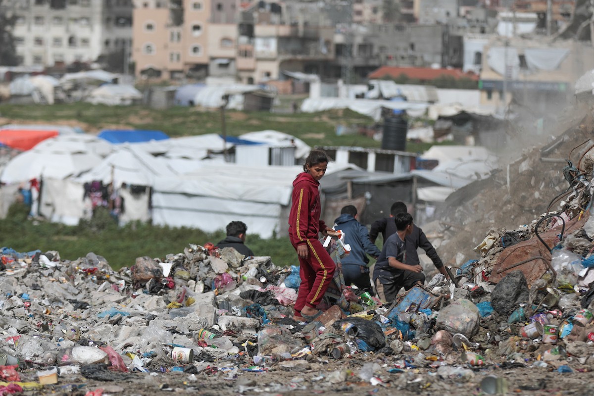 أطفال فلسطينيون يبحثون بين أكوام القمامة عن بقايا الطعام أو الألعاب في مكب نفايات بمخيم البريج للاجئين وسط قطاع غزة، في 4 أبريل/نيسان 2026، بالتزامن مع يوم الطفل الفلسطيني.(صورة: رمزي أبو عامر)