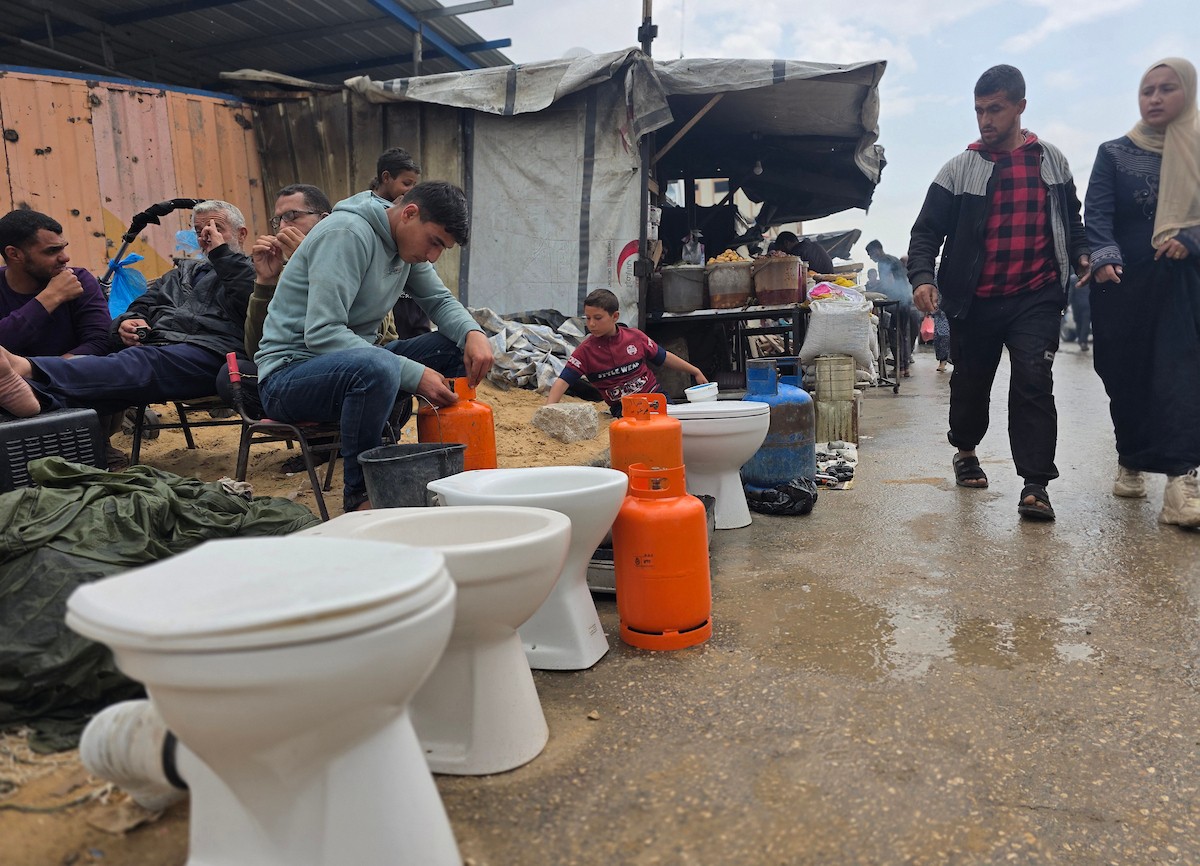 يبيع فلسطينيون موادًا مُستصلحة من أنقاض منازلهم المدمرة، بما في ذلك المعادن والخشب والأبواب ومستلزمات النظافة، في سوق للخردة بمنطقة المواصي في خان يونس جنوب قطاع غزة، في 27 أبريل/نيسان 2026 (صورة: طارق محمد)