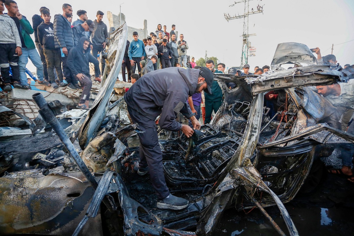 يتفقد فلسطينيون آثار غارة جوية إسرائيلية استهدفت مركبة في شارع صلاح الدين قرب مدخل مخيم المغازي للاجئين وسط قطاع غزة، في 4 أبريل/نيسان 2026.  (صورة: أحمد إبراهيم)