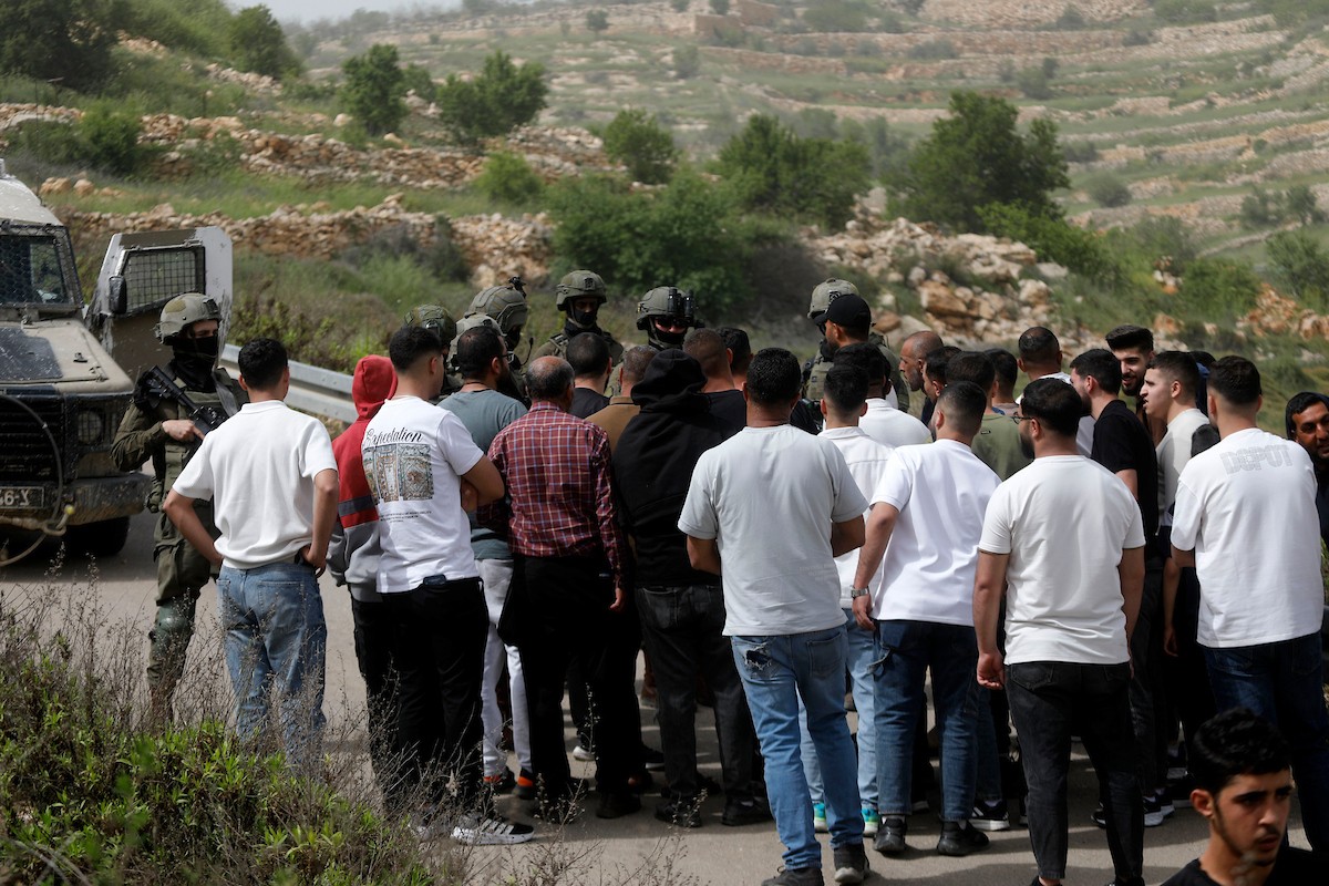 يحاول فلسطينيون الوصول إلى أراضيهم الزراعية في بلدة حلحول شمال الخليل جنوب الضفة الغربية، إلا أن الجيش الإسرائيلي يمنعهم من ذلك، وفق ما أفاد به شهود عيان،  17 أبريل/نيسان 2026. صورة: مأمون وزواز