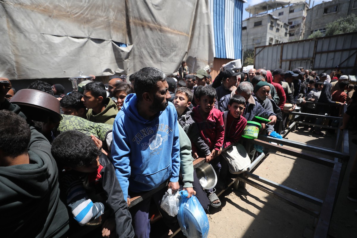 إحدى الجمعيات الخيرية توزع وجبات طعام على الفلسطينيين النازحين في مخيم النصيرات للاجئين، في ظل استمرار نقص الغذاء نتيجةً للسياسة الإسرائيلية المتعلقة بدخول المساعدات إلى مدينة غزة، في 11 أبريل/نيسان 2026. (تصوير: حسن جيدي)