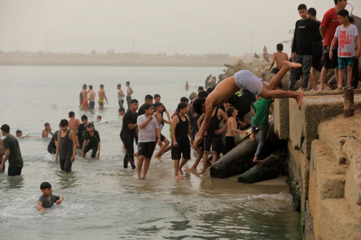 يقضي أطفال فلسطينيون أوقاتهم على شاطئ  غزة، باحثين عن ملاذ من حرارة الشمس وضغوط الحياة اليومية، في ظلّ الظروف الإنسانية المتردية التي يواجهها سكان القطاع جراء الحرب الدائرة، 17 أبريل/نيسان 2026. تصوير: بلال أسامة
