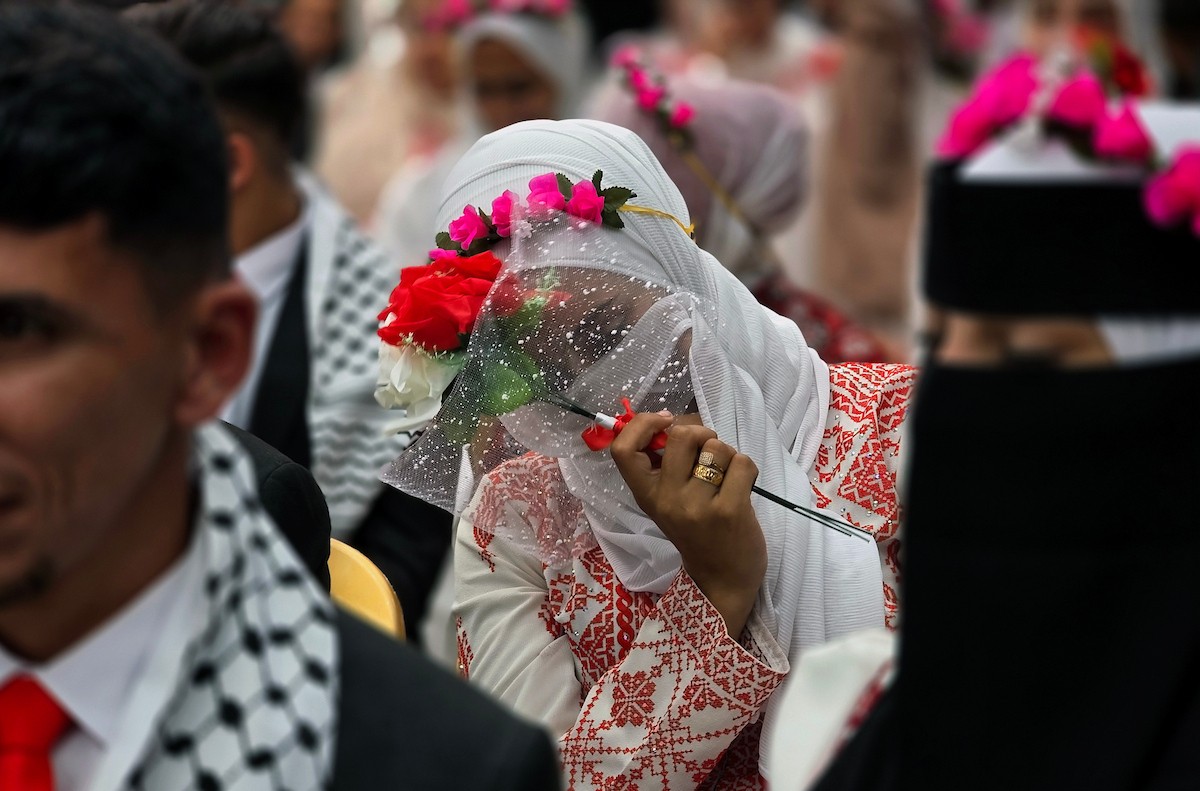 فلسطينيون يشاركون في حفل زفاف جماعي لخمسين عريساً فقدوا أفراداً من عائلاتهم خلال الحرب، ضمن مبادرة بعنوان أفراح رغم الجراح، في خان يونس، جنوب قطاع غزة. 26 أبريل/نيسان 2026، (تصوير: طارق محمد)