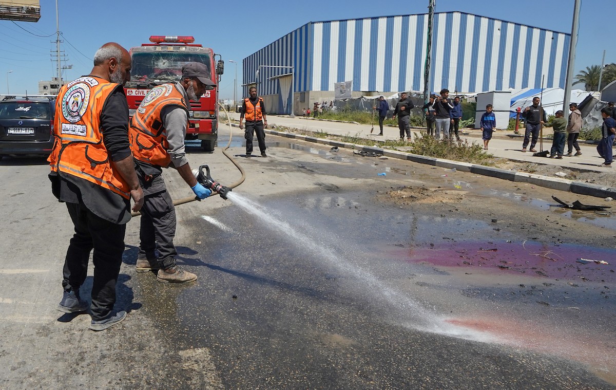فلسطينيون يتفقدون سيارة مدنية مدمرة بعد استهدافها في غارة جوية إسرائيلية أسفرت عن مقتل ثلاثة أشخاص في شارع صلاح الدين، جنوب مخيم البريج للاجئين وسط قطاع غزة، 23 أبريل/نيسان 2026. صورة: رمزي أبو عامر