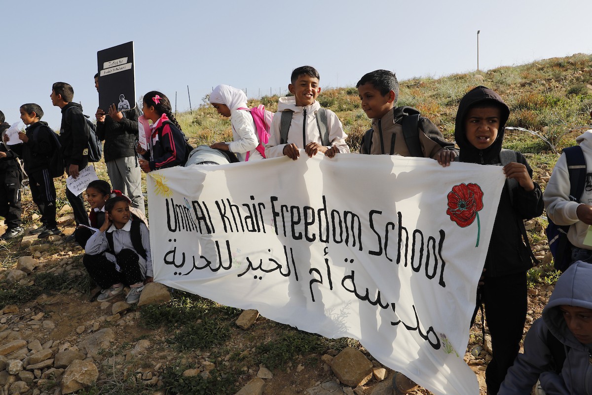 الخليل - أطفال خربة أم الخير وبمشاركة نشطاء سلام دوليين ينظمون وقفة سلمية احتجاجا على إغلاق الجيش الإسرائيلي للطريق الرئيسي المؤدي إلى مدارسهم منذ أسبوع، 19 أبريل/نيسان 2026. تصوير: مأمون وزواز