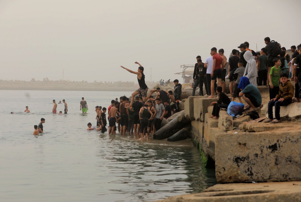 يقضي أطفال فلسطينيون أوقاتهم على شاطئ  غزة، باحثين عن ملاذ من حرارة الشمس وضغوط الحياة اليومية، في ظلّ الظروف الإنسانية المتردية التي يواجهها سكان القطاع جراء الحرب الدائرة، 17 أبريل/نيسان 2026. تصوير: بلال أسامة