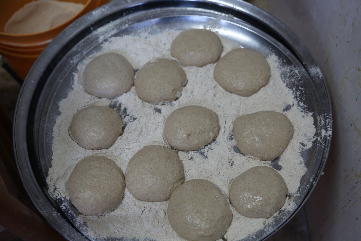 في 29 أبريل/نيسان 2026، عائلات سامرية تُعد خبز طري لطقوس ذبح الأضاحي في عيد الفصح على جبل جرزيم، المطل على مدينة نابلس في الضفة الغربية. ويعيش نحو 700 سامري بين مدينة نابلس في الضفة الغربية ومدينة حولون جنوب تل أبيب. (صورة: محمد ناصر)