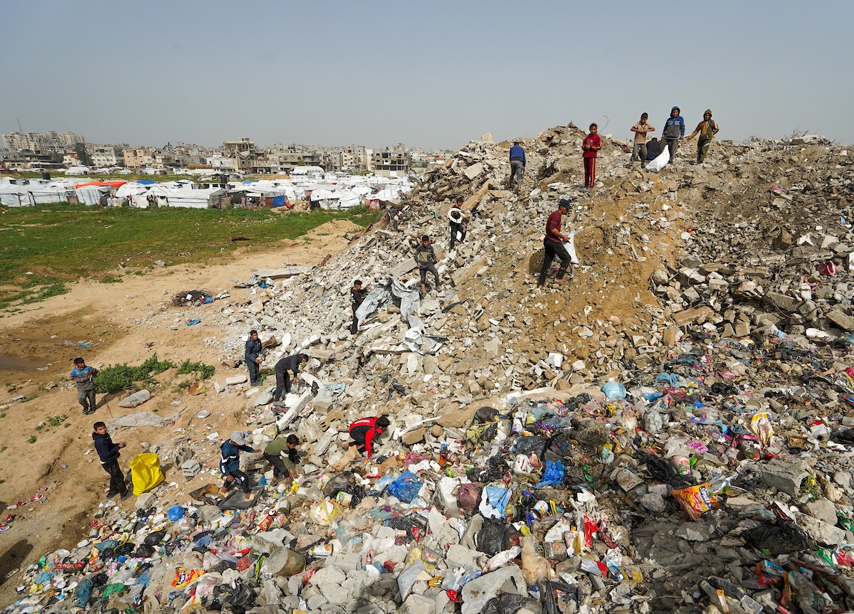 أطفال فلسطينيون يبحثون بين أكوام القمامة عن بقايا الطعام أو الألعاب في مكب نفايات بمخيم البريج للاجئين وسط قطاع غزة، في 4 أبريل/نيسان 2026، بالتزامن مع يوم الطفل الفلسطيني.(صورة: رمزي أبو عامر)