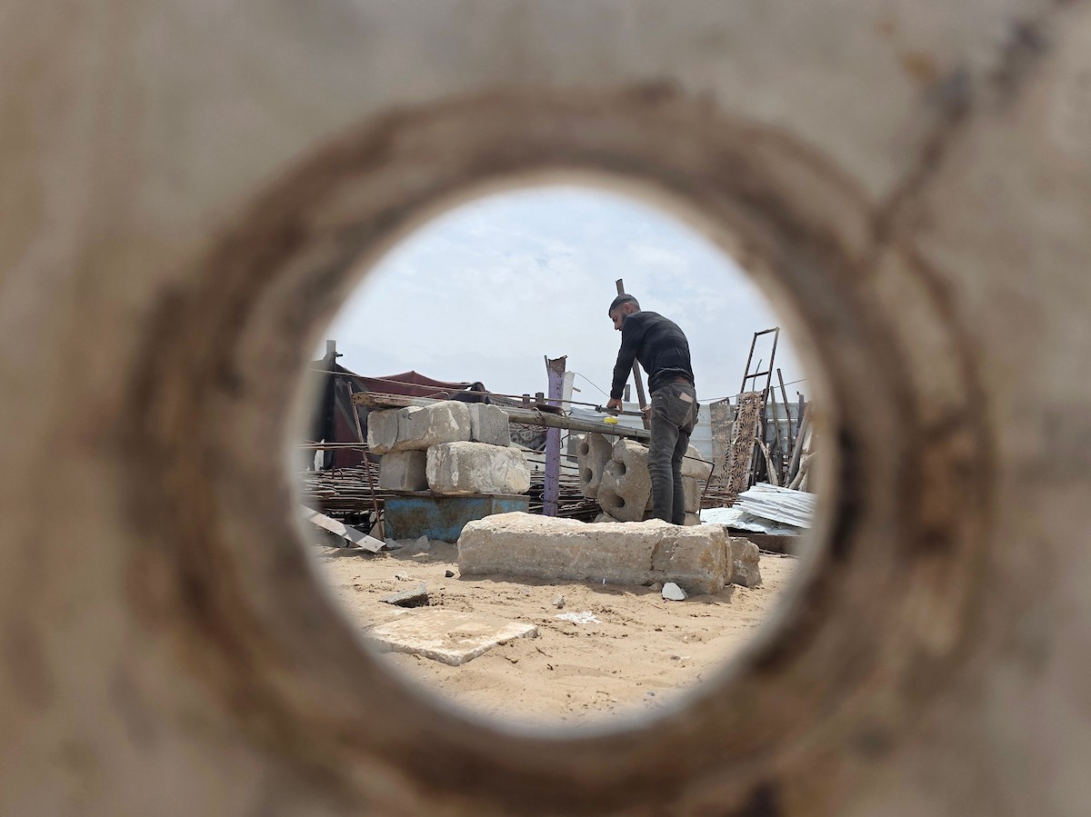 يبيع فلسطينيون موادًا مُستصلحة من أنقاض منازلهم المدمرة، بما في ذلك المعادن والخشب والأبواب ومستلزمات النظافة، في سوق للخردة بمنطقة المواصي في خان يونس جنوب قطاع غزة، في 27 أبريل/نيسان 2026 (صورة: طارق محمد)