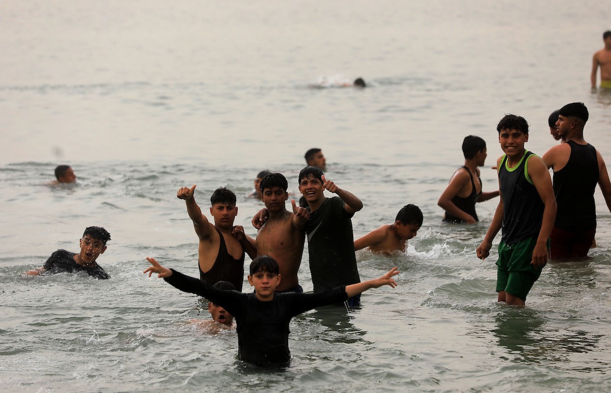 يقضي أطفال فلسطينيون أوقاتهم على شاطئ  غزة، باحثين عن ملاذ من حرارة الشمس وضغوط الحياة اليومية، في ظلّ الظروف الإنسانية المتردية التي يواجهها سكان القطاع جراء الحرب الدائرة، 17 أبريل/نيسان 2026. تصوير: بلال أسامة
