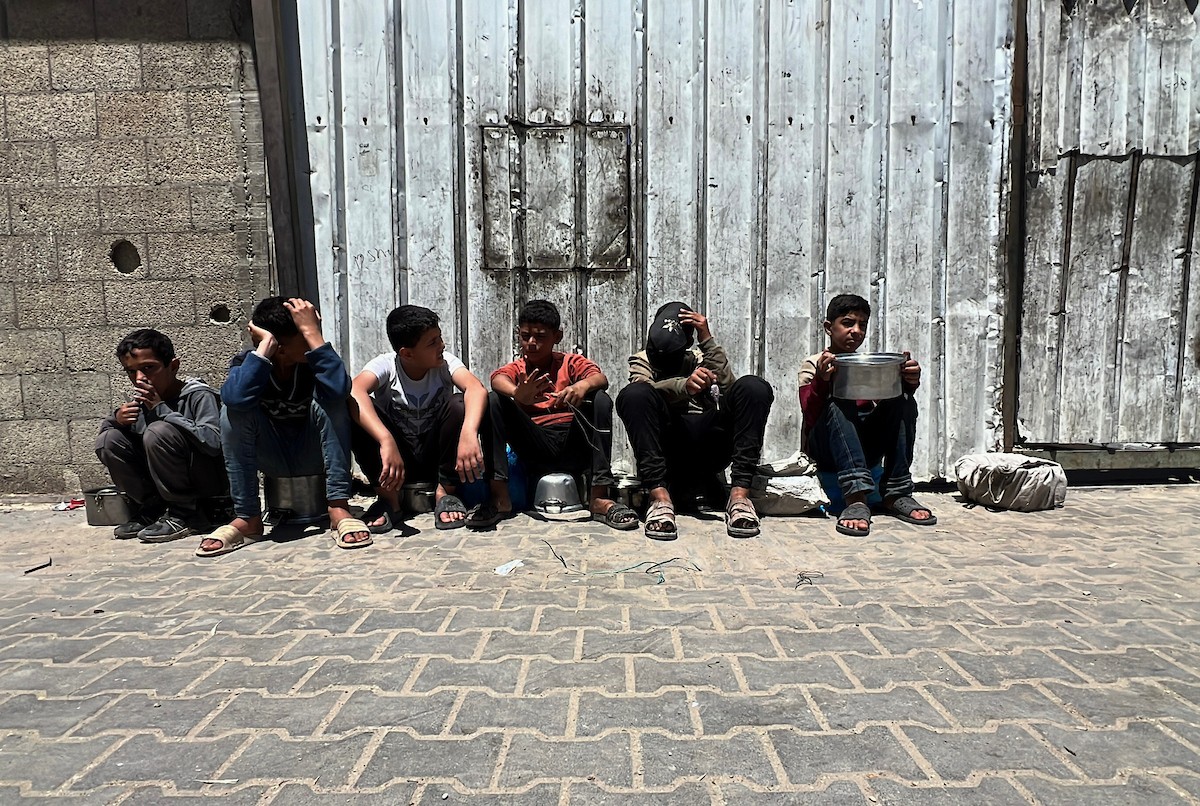 يتلقى فلسطينيون نازحون طعامًا من مطبخ خيري في مخيم النصيرات للاجئين وسط قطاع غزة، في 23 أبريل/نيسان 2026، (صورة: يوسف أبو وطفة)