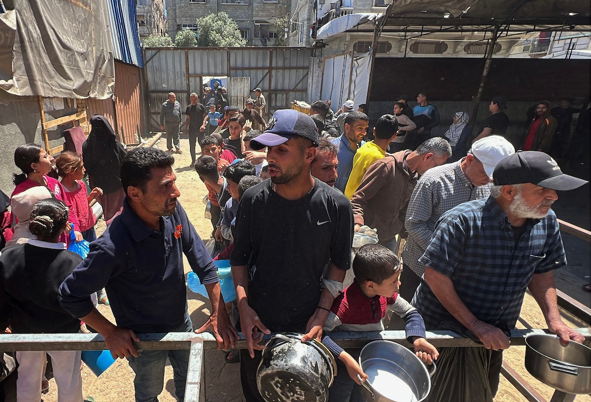 يتلقى فلسطينيون نازحون طعامًا من مطبخ خيري في مخيم النصيرات للاجئين وسط قطاع غزة، في 23 أبريل/نيسان 2026، (صورة: يوسف أبو وطفة)
